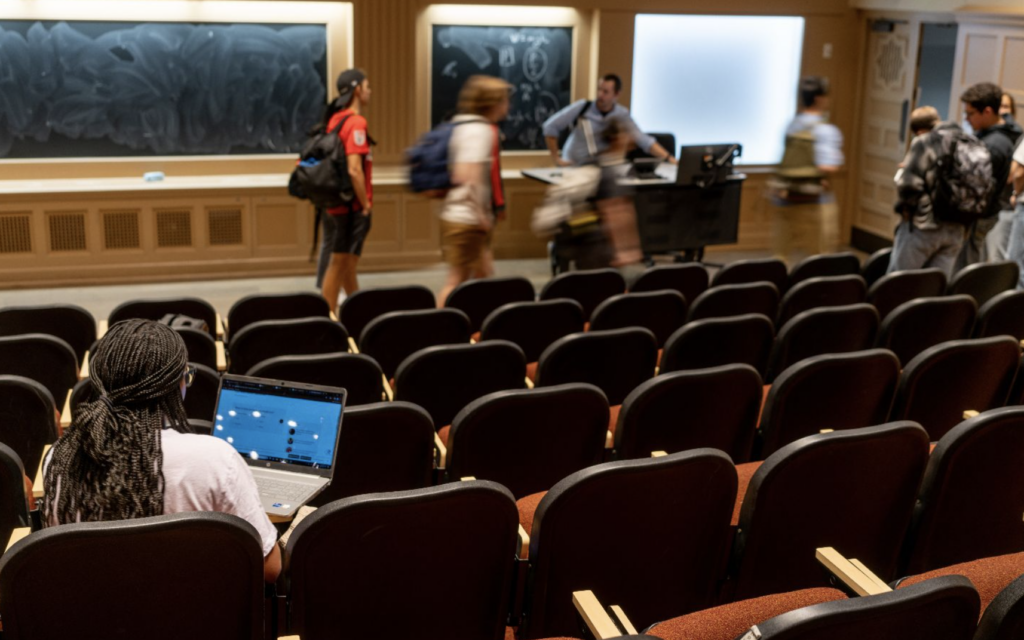 A student student sits in a lecture hall while class is being dismissed at the University of Texas at Austin.