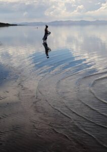 People wade in the waters of the Great Salt Lake at Antelope Island in August 2021.